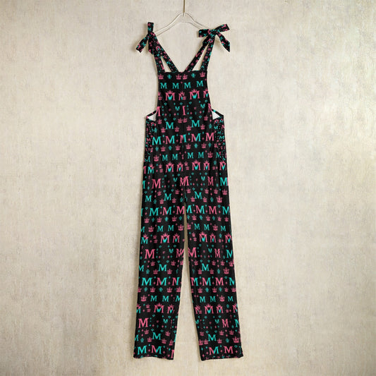 Munsieur luxury designer women's jumpsuit with colorful M pattern and bow straps hanging on hanger
